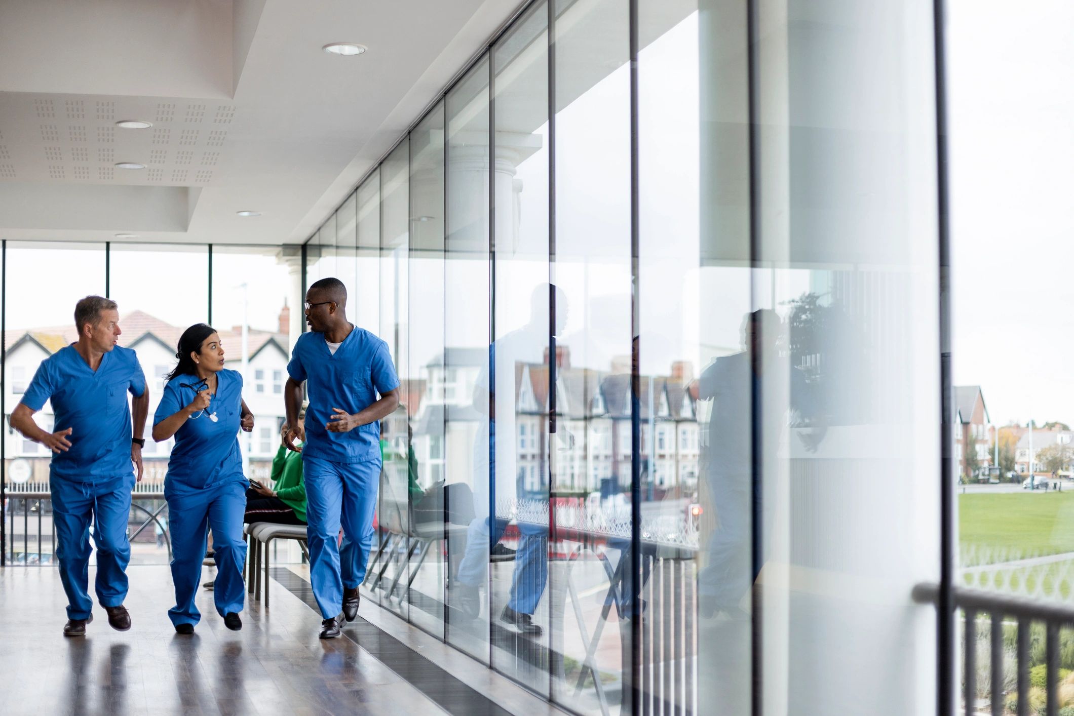 Medical professionals moving quickly through a hospital corridor